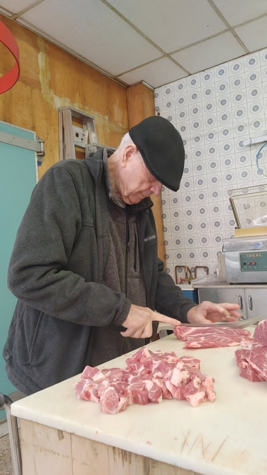 Our butcher cutting fresh meat into cubes at the block